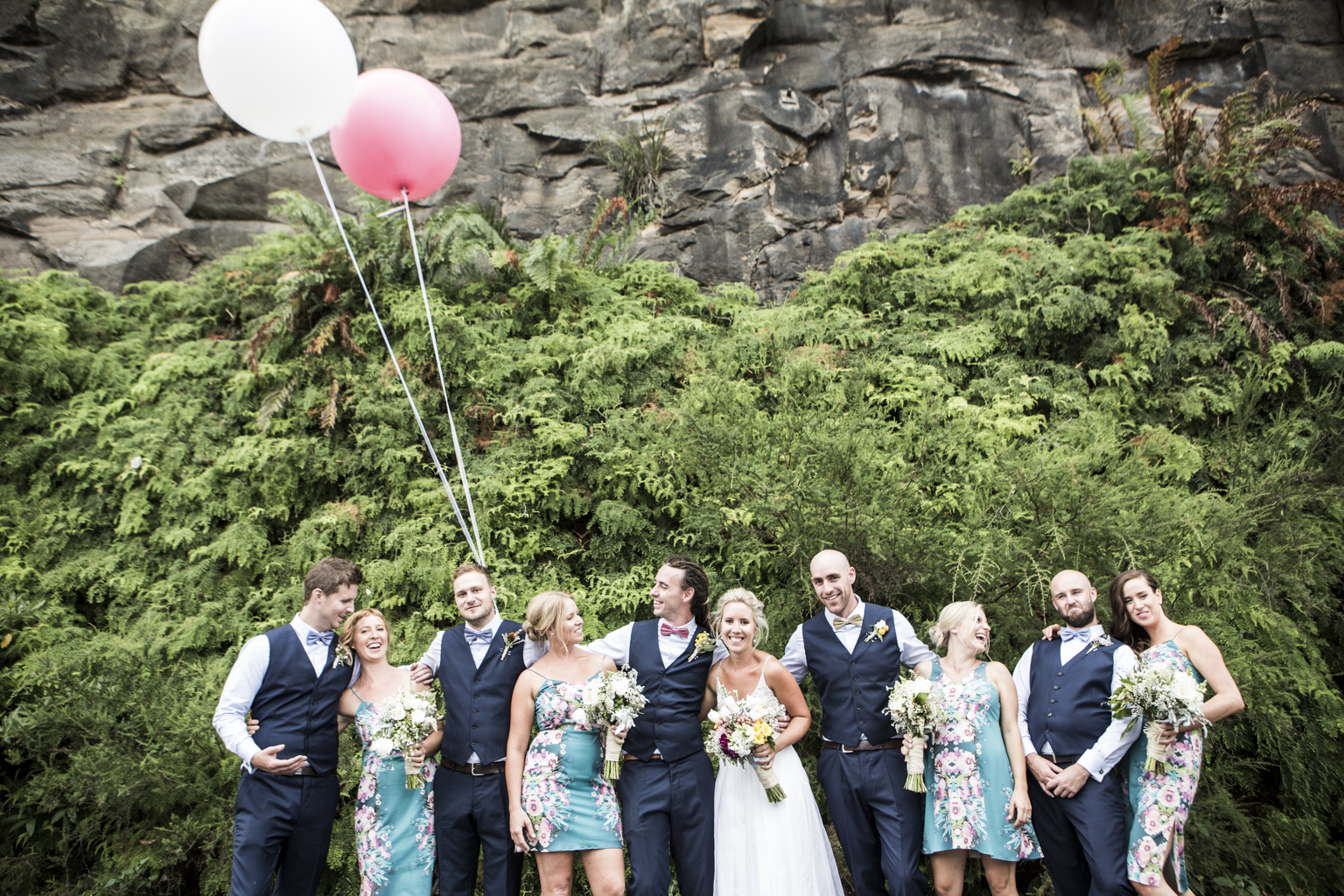 Bridal party having a laugh with giant pink and white balloons