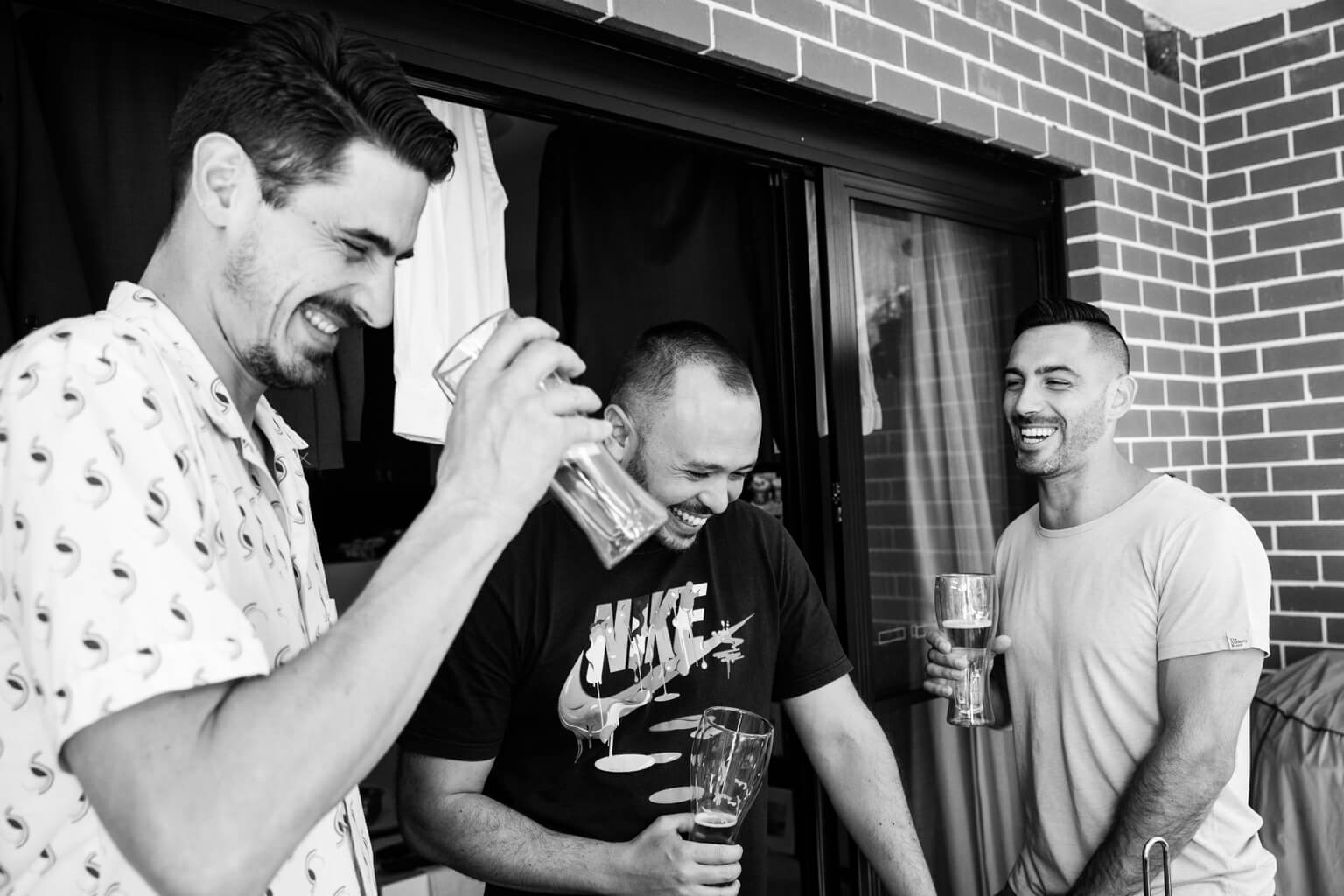 Groom and best me laughing drinking beer whilst getting ready