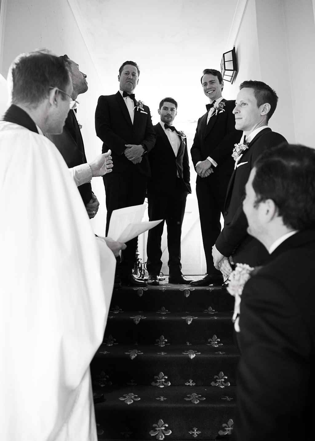 groom and best men listening to instructions form the priest before wedding